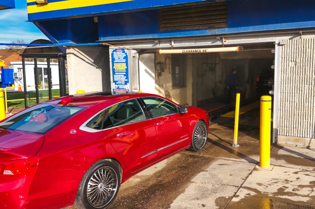 Red sedan entering Jax Kar Wash tunnel Birmingham