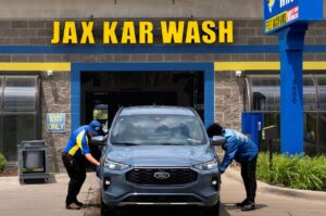 Jax Kar Wash staff cleaning vehicle at entrance bay
