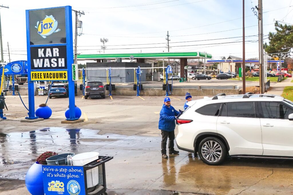 Jax Kar Wash exterior with staff drying white SUV