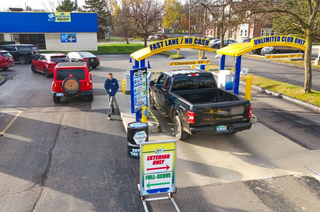 Exterior car wash lane with vehicles at Jax