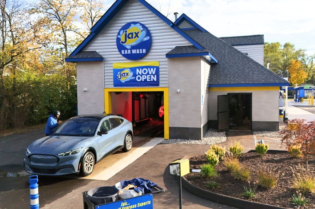 Car exiting Jax car wash building with now open sign