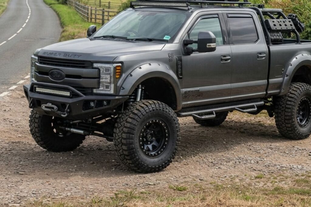 Dark lifted pickup parked beside a highway