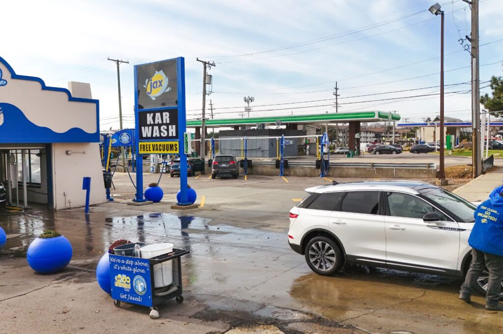 Exterior view of Jax Karwash with a large sign advertising free vacuums.