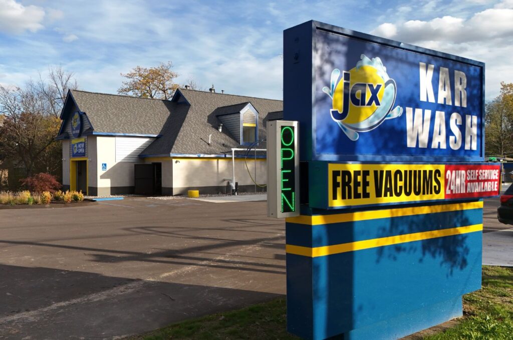 Prominent Jax Karwash signs highlighting free vacuums and 24-hour self-service availability.